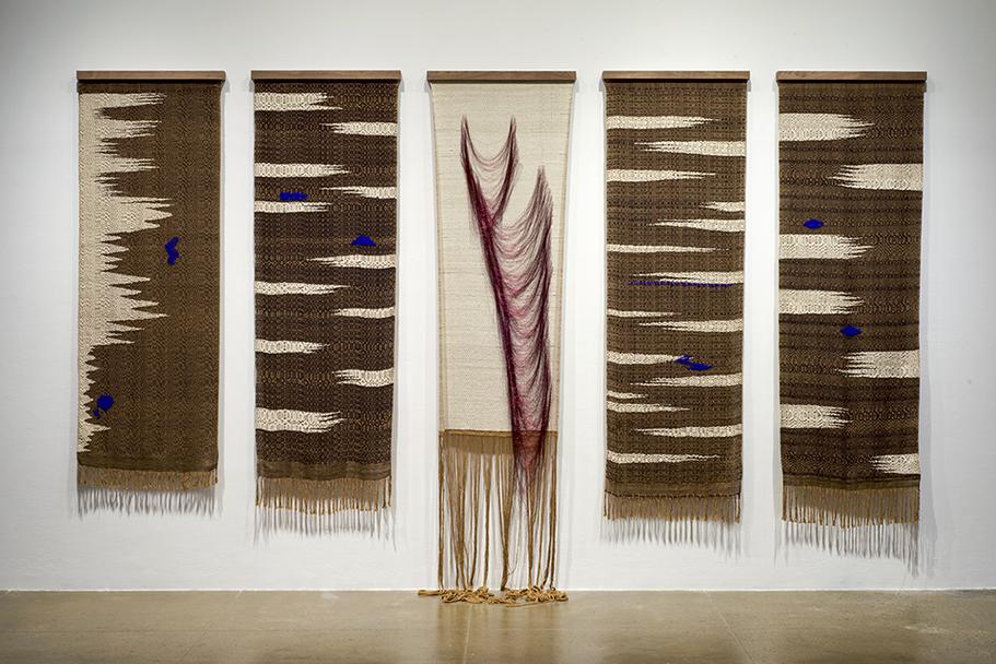 Jenelle Esparza, Gathering Bones, handwoven tapestries; natural white and natural brown cotton yarn, dyed black cotton, Japanese blue silk, and red gimp metallic yarn on walnut hangers, 2018. Originally commissioned and produced by Artpace San Antonio. Ph